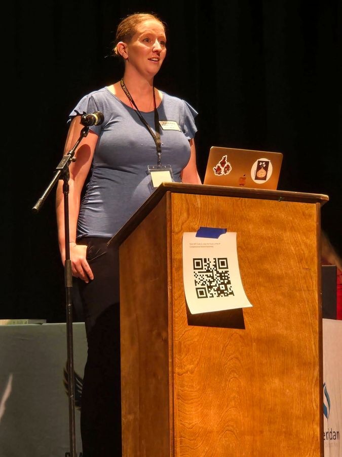 Rebecca Winegar speaking at the CD6 Assembly podium, March 2026