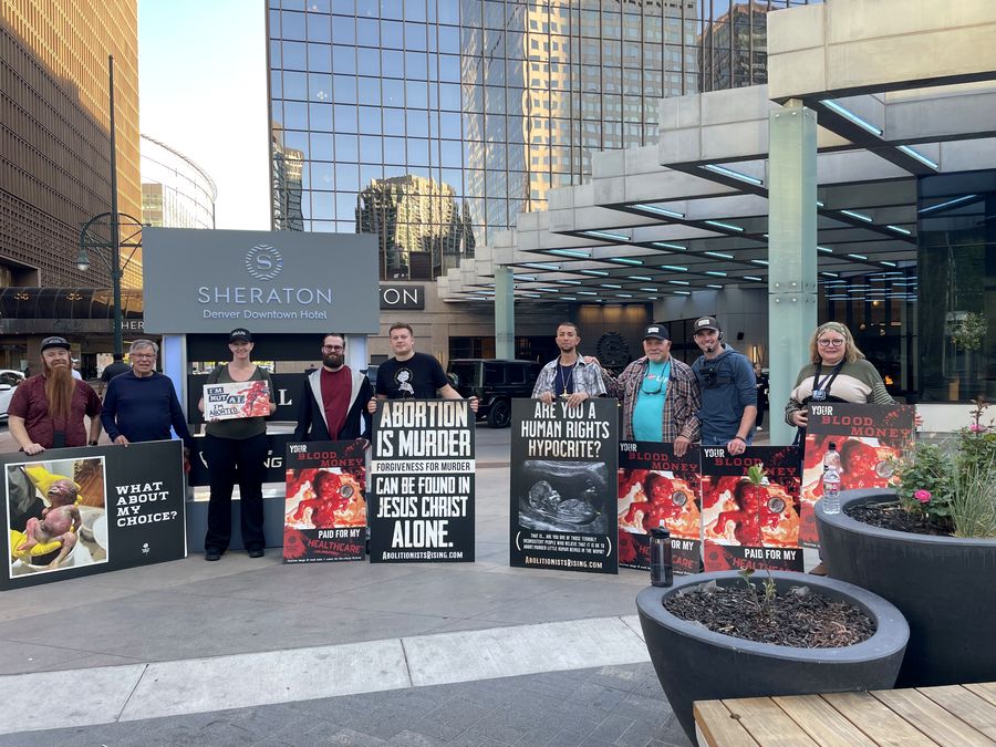 Rebecca Winegar with the White Rose Resistance group protesting the Cobalt Advocates Annual Fundraising Gala outside the Sheraton Denver Downtown Hotel, May 2026